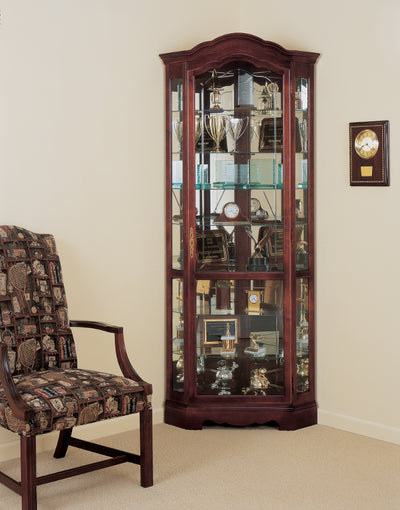 HM-680-249 - Jamestown Corner Curio shown in a room setting next to a chair and a clock on the wall - Oak For Less® Furniture